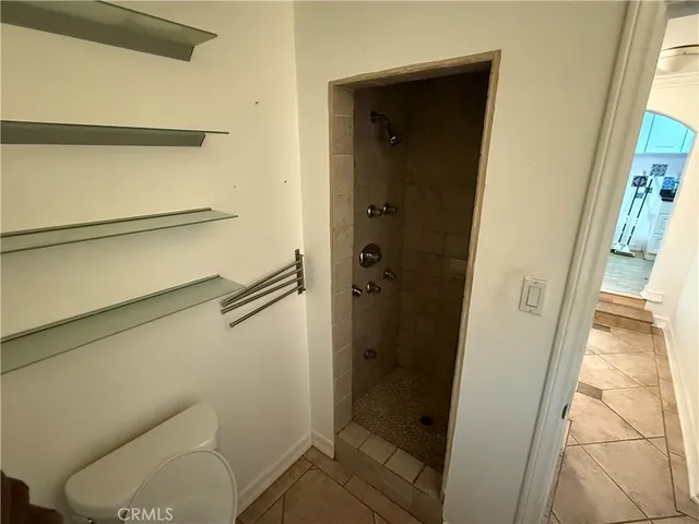a bathroom with a granite countertop shower and a toilet