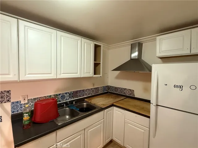 a kitchen with granite countertop white cabinets and white appliances