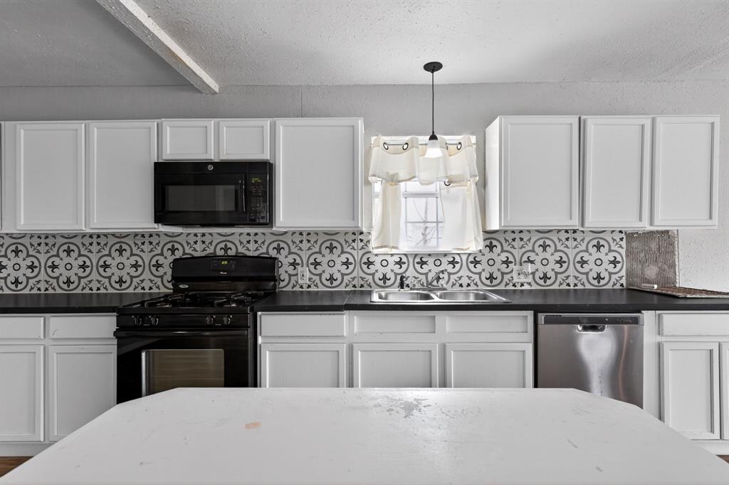 205 South Mable Street Ferris, TX 75125 - Photo 13 of 31 a kitchen with granite countertop a stove and a sink