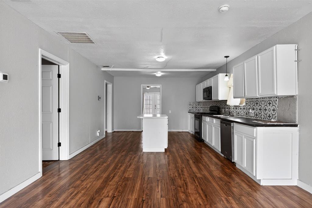 205 South Mable Street Ferris, TX 75125 - Photo 16 of 31 a kitchen with a refrigerator and white cabinets