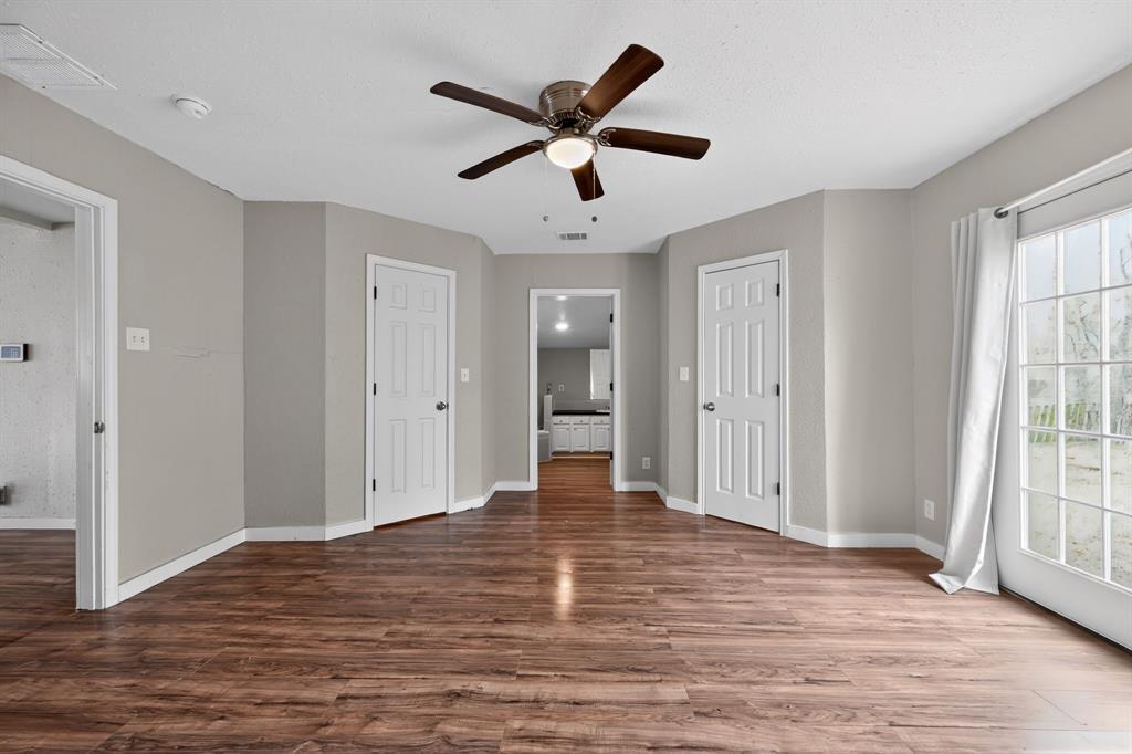 205 South Mable Street Ferris, TX 75125 - Photo 18 of 31 a view of empty room with wooden floor and ceiling fan