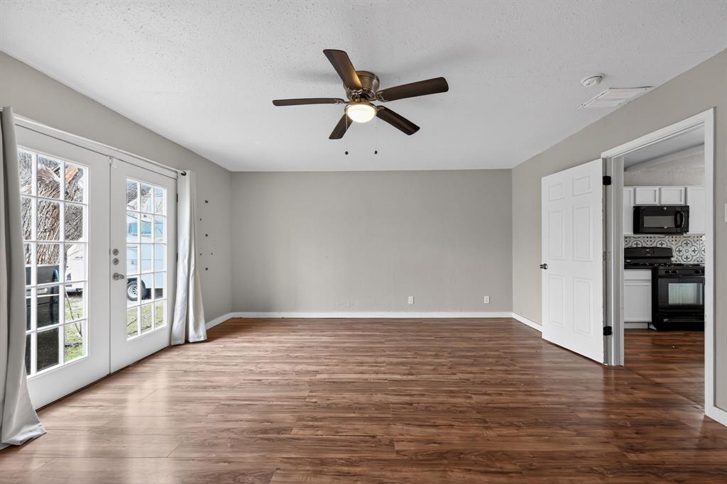 205 South Mable Street Ferris, TX 75125 - Photo 5 of 31 a view of empty room with wooden floor and ceiling fan