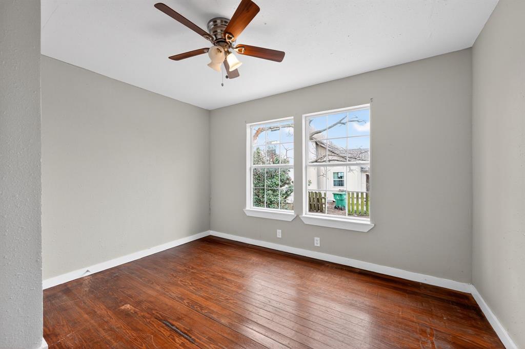 205 South Mable Street Ferris, TX 75125 - Photo 6 of 31 an empty room with wooden floor and windows