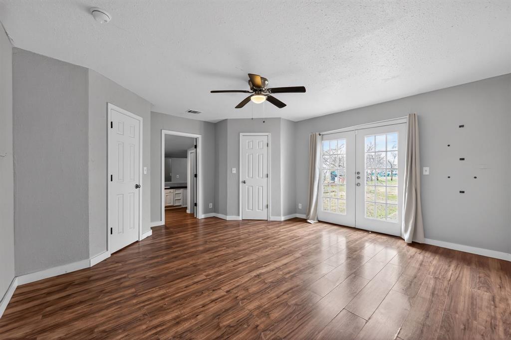 205 South Mable Street Ferris, TX 75125 - Photo 9 of 31 a view of an empty room with wooden floor and a ceiling fan