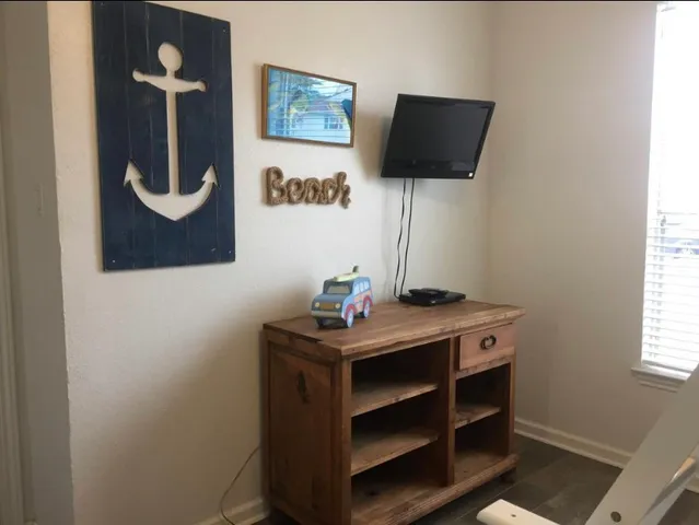 a room that has a dresser and a flat screen tv