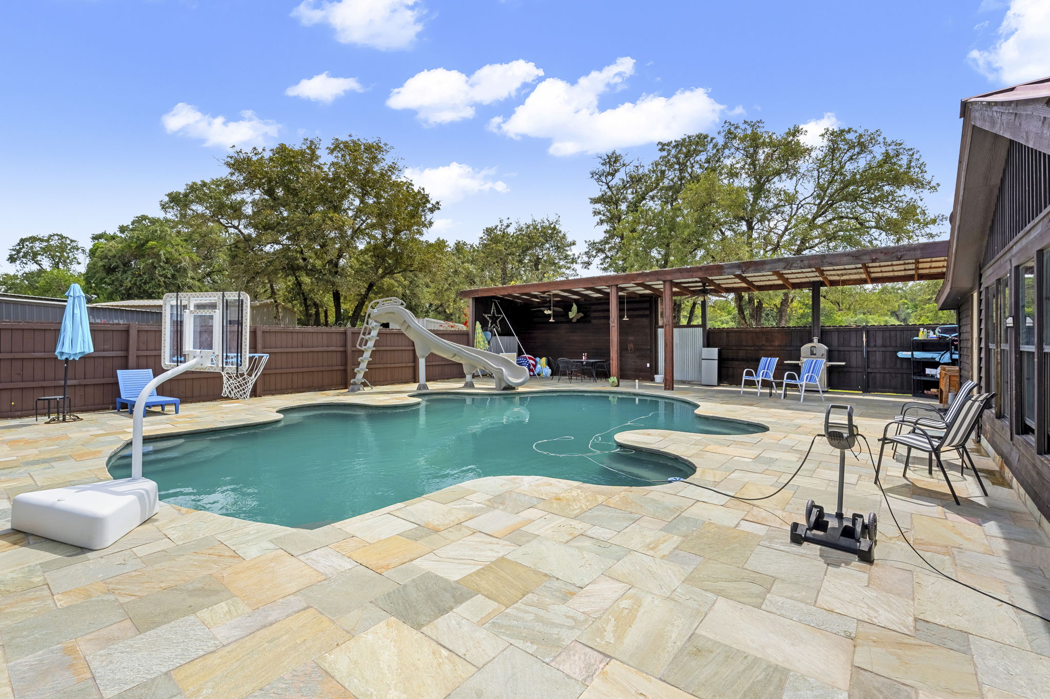 206 22 Hills Road Gause, TX 77857 - Photo 12 of 28 An inviting swimming pool is bordered by spacious stone paving and a covered patio structure.