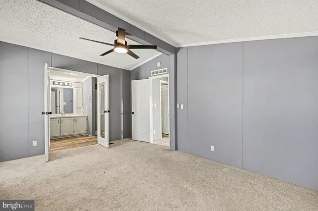 a view of a livingroom with a chandelier fan and windows