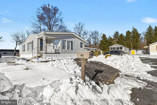 a view of a white house with a yard covered in snow