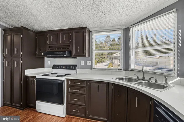 a kitchen with a sink stove top oven and cabinets