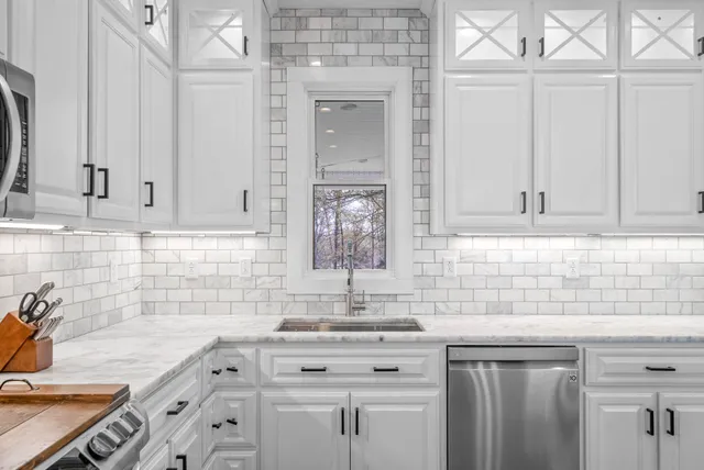 a kitchen with stainless steel appliances granite countertop a stove top oven a sink dishwasher a dining table and chairs with wooden floor