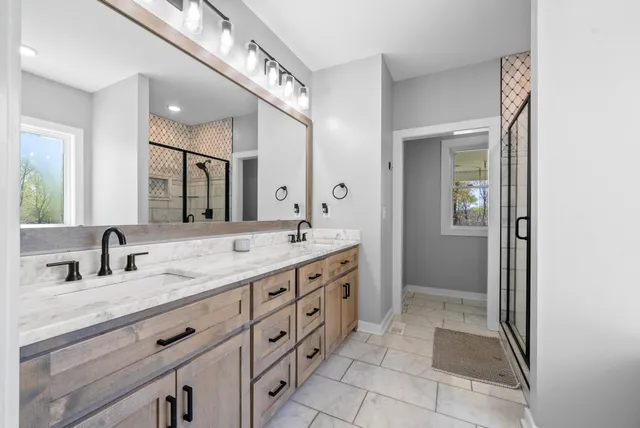 a spacious bathroom with a double vanity sink a mirror and a bathtub