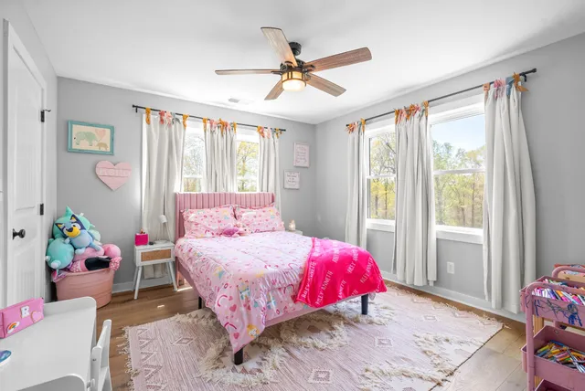 a bedroom with a bed and wooden floor