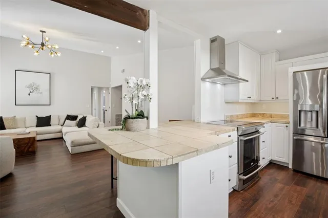 a open kitchen with stainless steel appliances kitchen island granite countertop a stove and a refrigerator