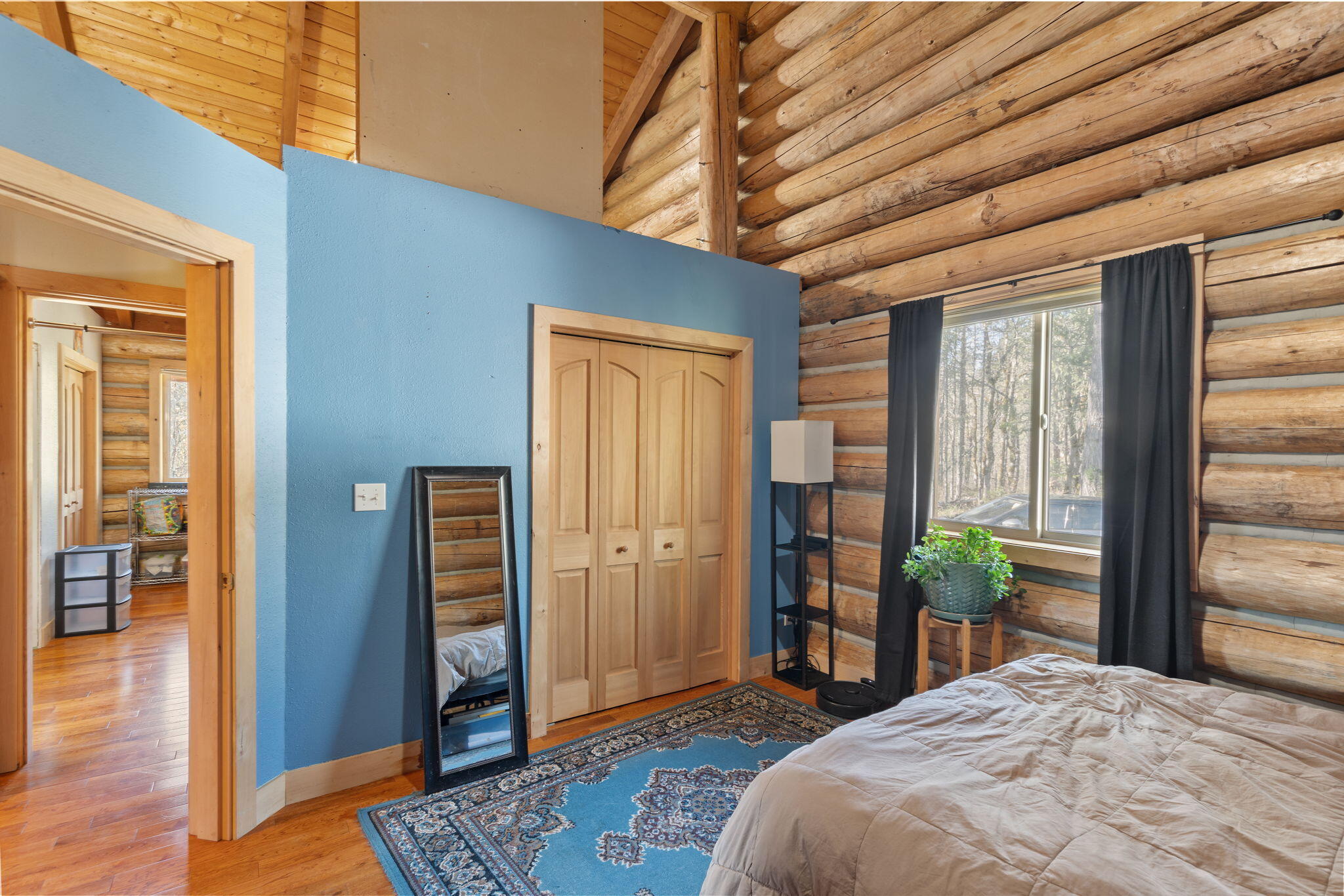 5737 Rockydale Road Cave Junction, OR 97523 - Photo 10 of 39 a bedroom with a large bed a chandelier and dresser