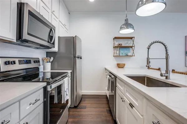 a kitchen with stainless steel appliances granite countertop a sink and a stove