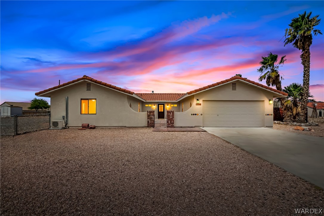 4088 Mercer Road Bullhead City, AZ 86429 - Photo 1 of 35 Southwestern-style stucco residence featuring a terra cotta tile roof and a two-car garage