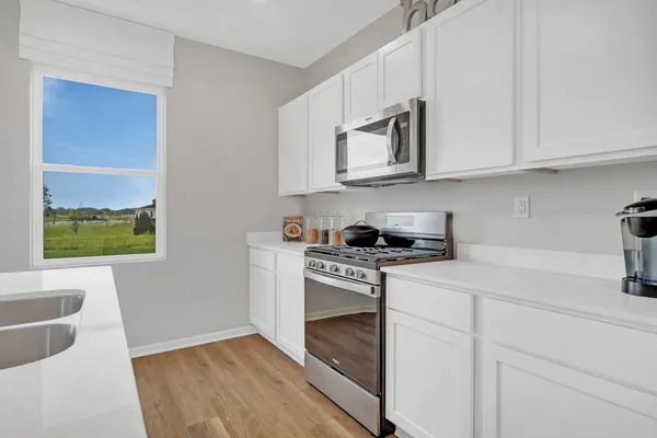 a kitchen with stainless steel appliances granite countertop white cabinets and a stove