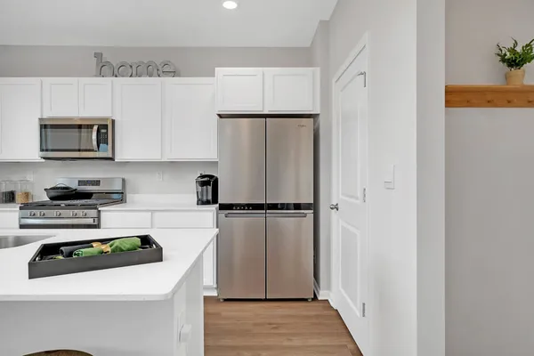 a kitchen with a refrigerator a stove a microwave and cabinets