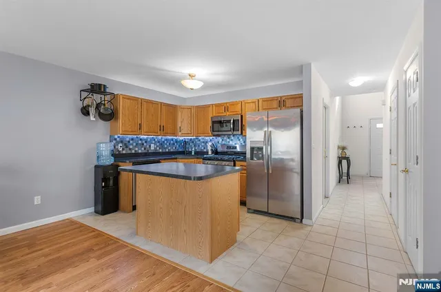 a kitchen with stainless steel appliances granite countertop a refrigerator and a sink