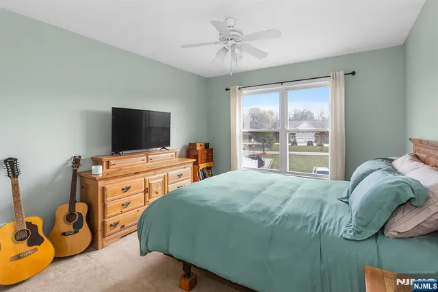 a bedroom with a bed and a flat tv screen on the dresser