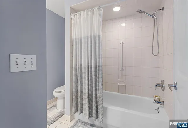 a bathroom with a shower a toilet and bathtub