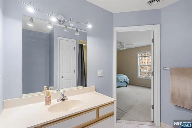 a en suite bathroom with a sink shower and a mirror