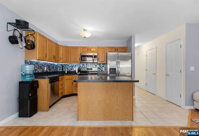 a kitchen with stainless steel appliances granite countertop wooden cabinets a granite counter tops and a sink
