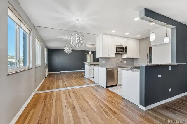 a open kitchen with kitchen island white cabinets and stainless steel appliances