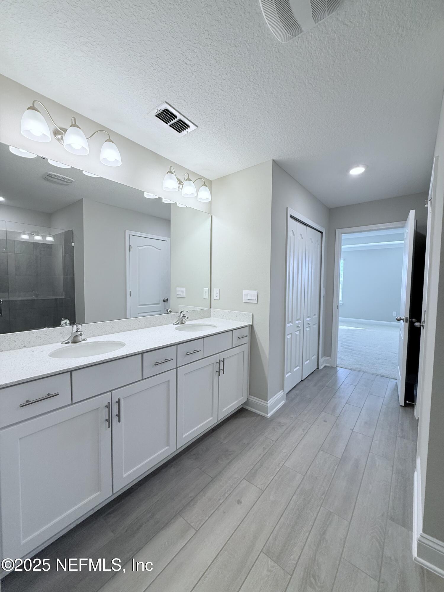 23 Alagon Way Street St. Augustine, FL 32084 - Photo 11 of 39 a large bathroom with a double vanity sink and a mirror