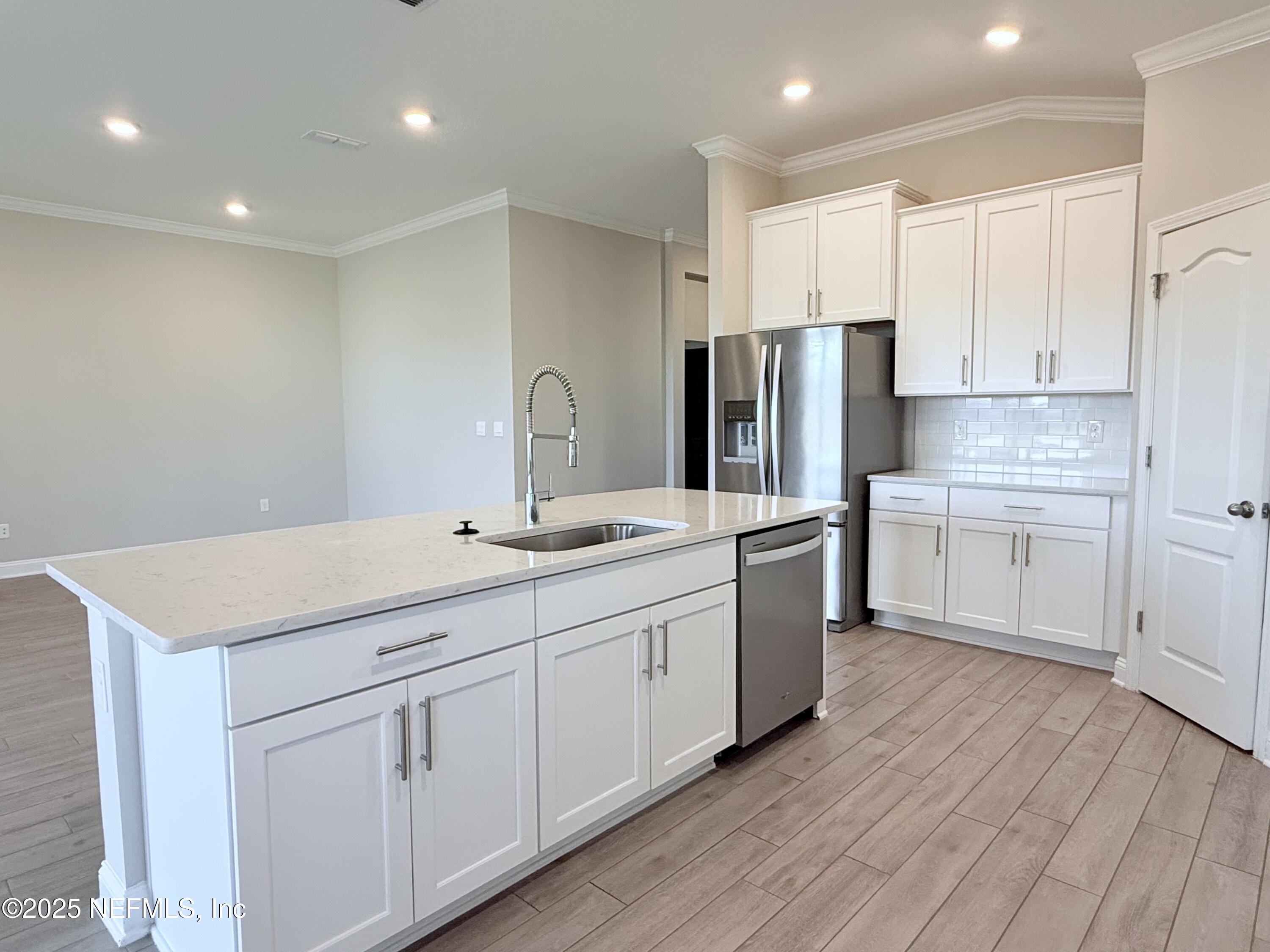 23 Alagon Way Street St. Augustine, FL 32084 - Photo 3 of 39 a kitchen with white cabinets white stainless steel appliances and sink