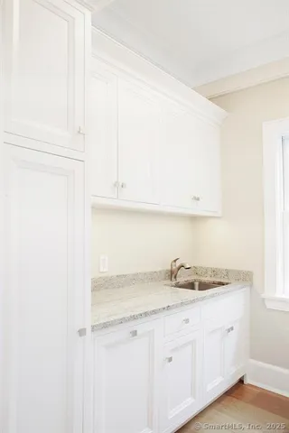 a kitchen with granite countertop white cabinets and a sink