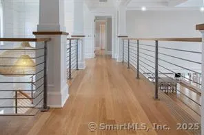 a view of a hallway with wooden floor and staircase