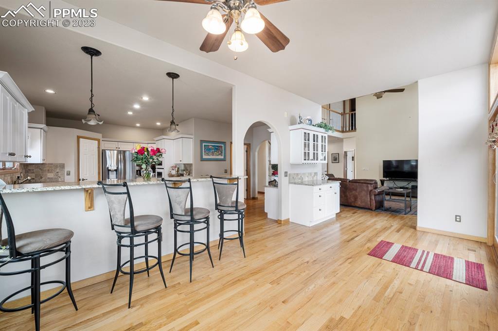750 Bowstring Road Monument, CO 80132 - Photo 15 of 34 a living room with furniture and kitchen view with wooden floor