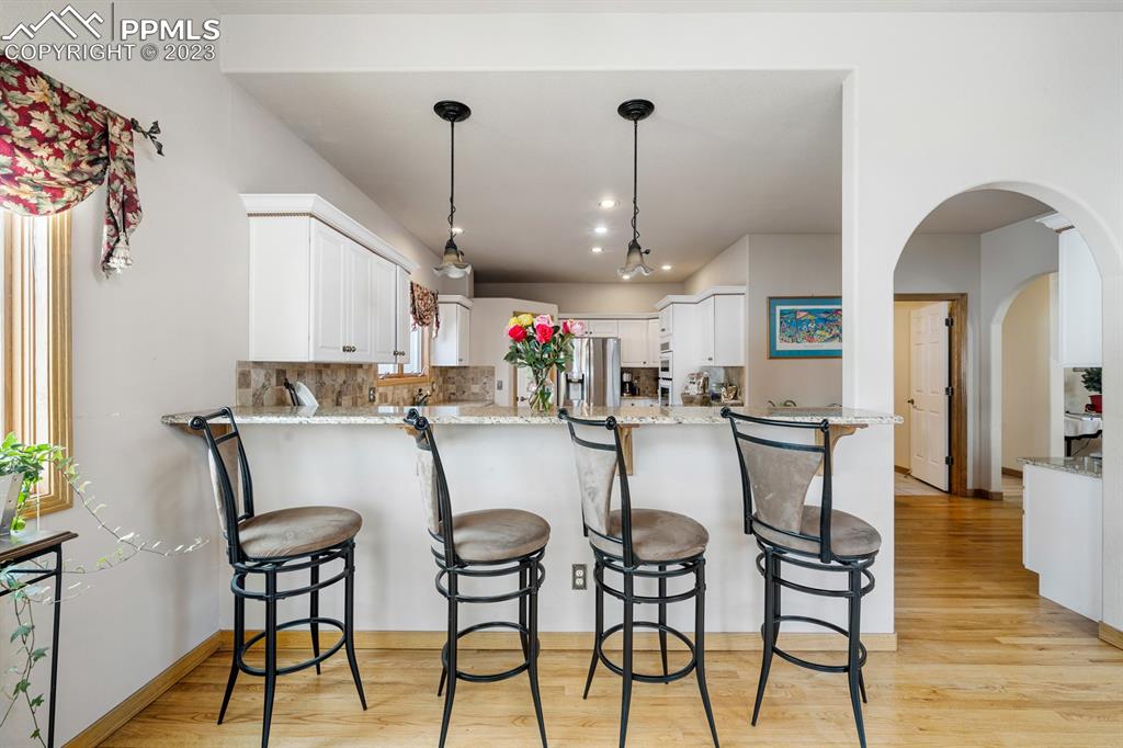 750 Bowstring Road Monument, CO 80132 - Photo 16 of 34 a dining room filled chandelier and wooden floor