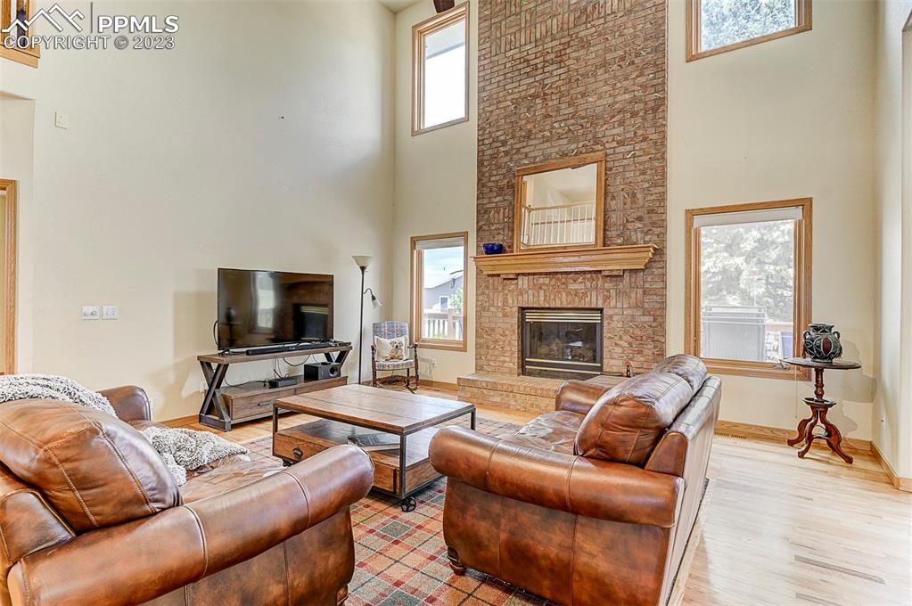 750 Bowstring Road Monument, CO 80132 - Photo 18 of 34 a living room with furniture wooden floor and a fireplace