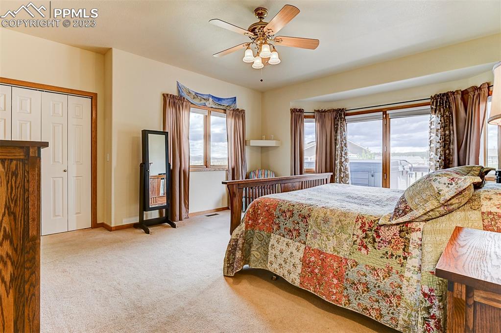 750 Bowstring Road Monument, CO 80132 - Photo 19 of 34 a bed sitting in a spacious bedroom next to a window