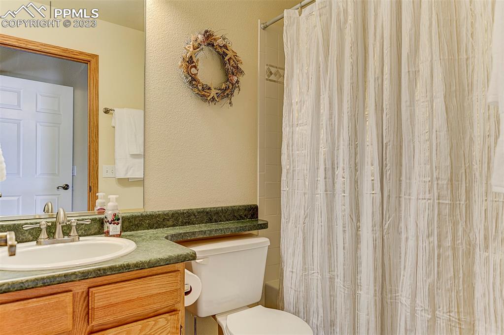 750 Bowstring Road Monument, CO 80132 - Photo 30 of 34 a bathroom with a granite countertop sink and a mirror