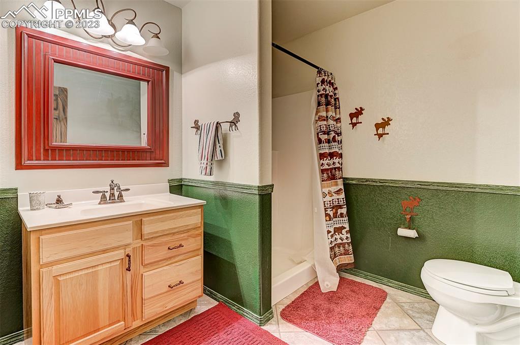 750 Bowstring Road Monument, CO 80132 - Photo 32 of 34 a bathroom with a toilet sink and mirror