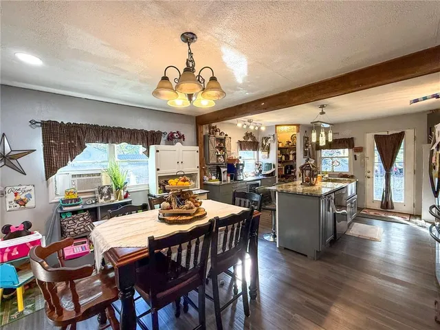 a view of a dining room with furniture a chandelier and wooden floor