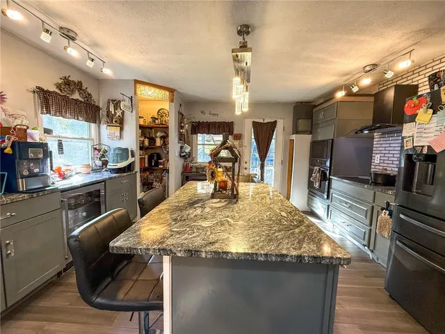 a kitchen with stainless steel appliances kitchen island granite countertop a sink and cabinets