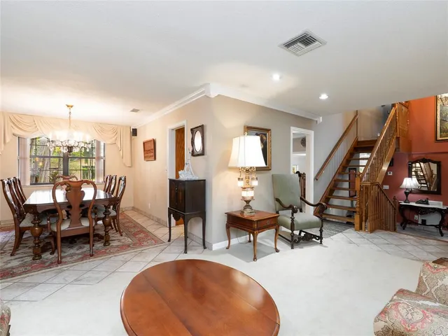 a living room with furniture kitchen view and a wooden floor
