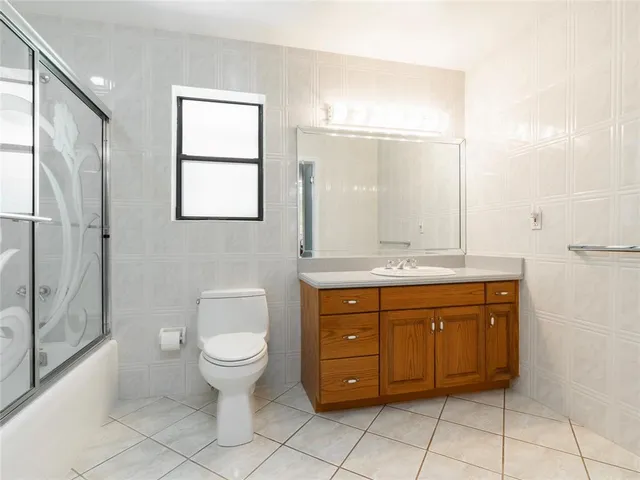 a bathroom with a granite countertop toilet sink and mirror