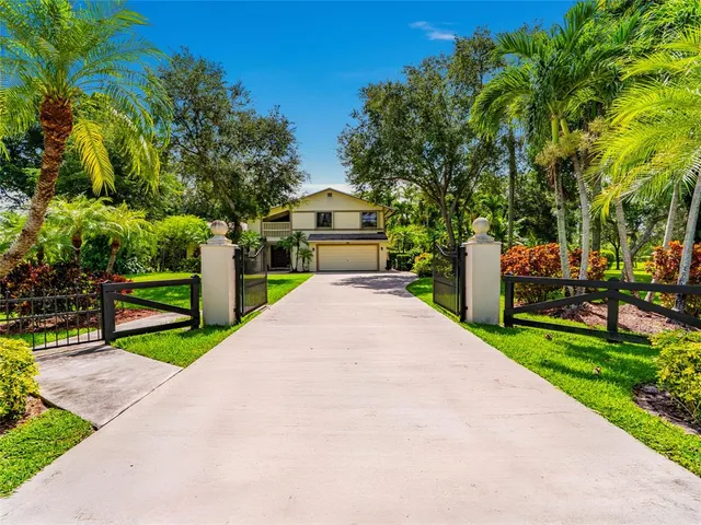 a front view of a house with fountain and garden