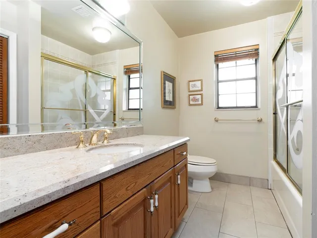 a bathroom with a granite countertop sink toilet and shower
