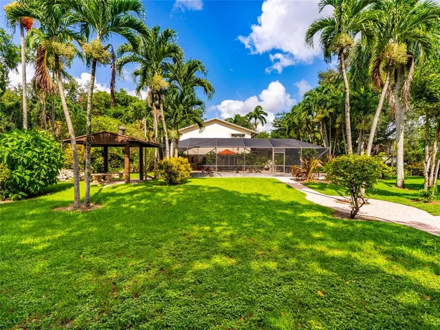 a view of a house with a big yard and potted plants