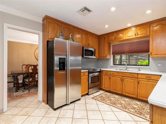 a kitchen with stainless steel appliances granite countertop a refrigerator and a sink