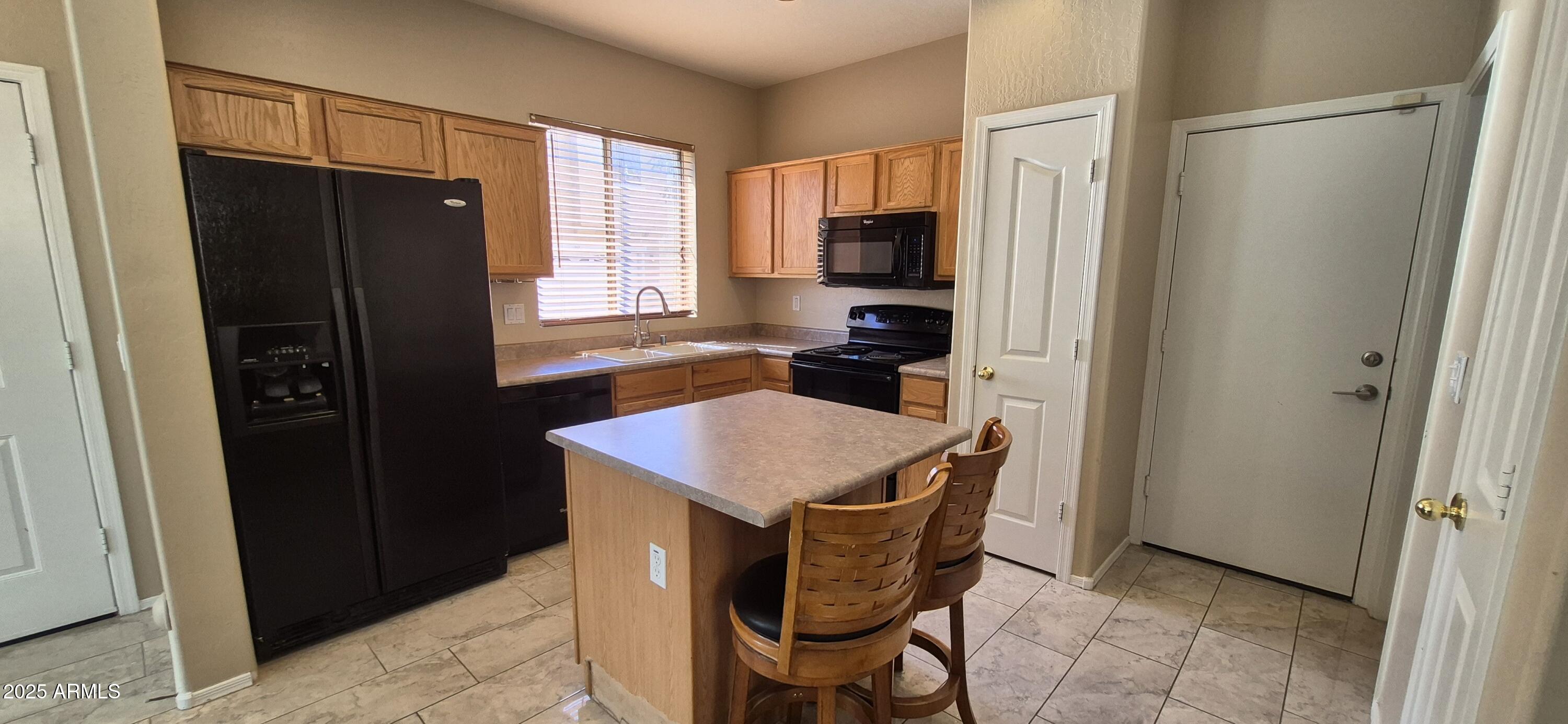 1347 East Dunbar Drive Phoenix, AZ 85042 - Photo 2 of 19 a kitchen with stainless steel appliances a refrigerator and a stove top oven
