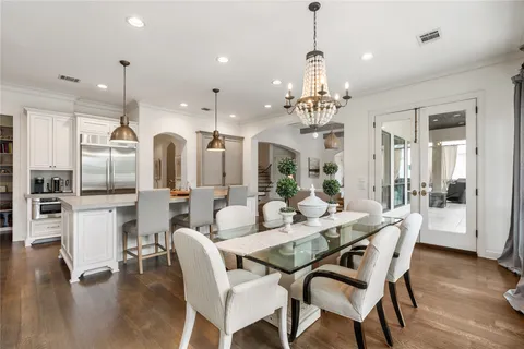 a dining room with furniture a chandelier and wooden floor