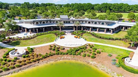an aerial view of a house with swimming pool and large trees