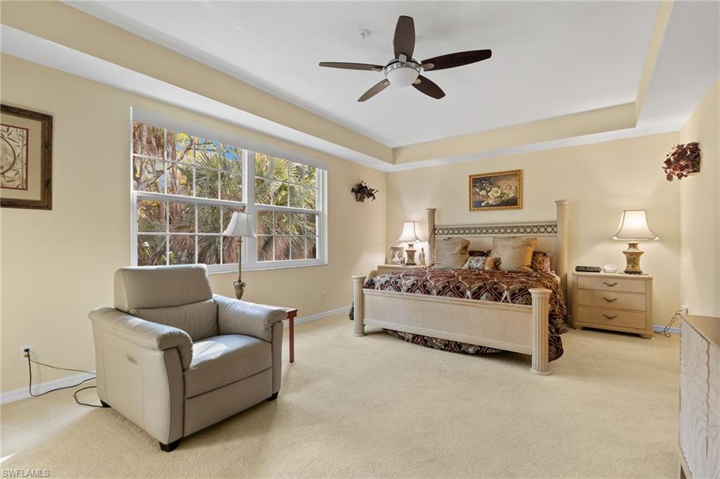 1665 Winding Oaks Way, Unit 202 Naples, FL 34109 - Photo 19 of 34 Bedroom with carpet floors, ceiling fan, and a raised ceiling